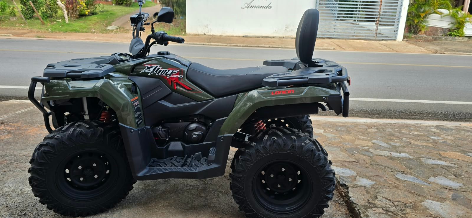 Side view of J&R’s green ATV with passenger backrest